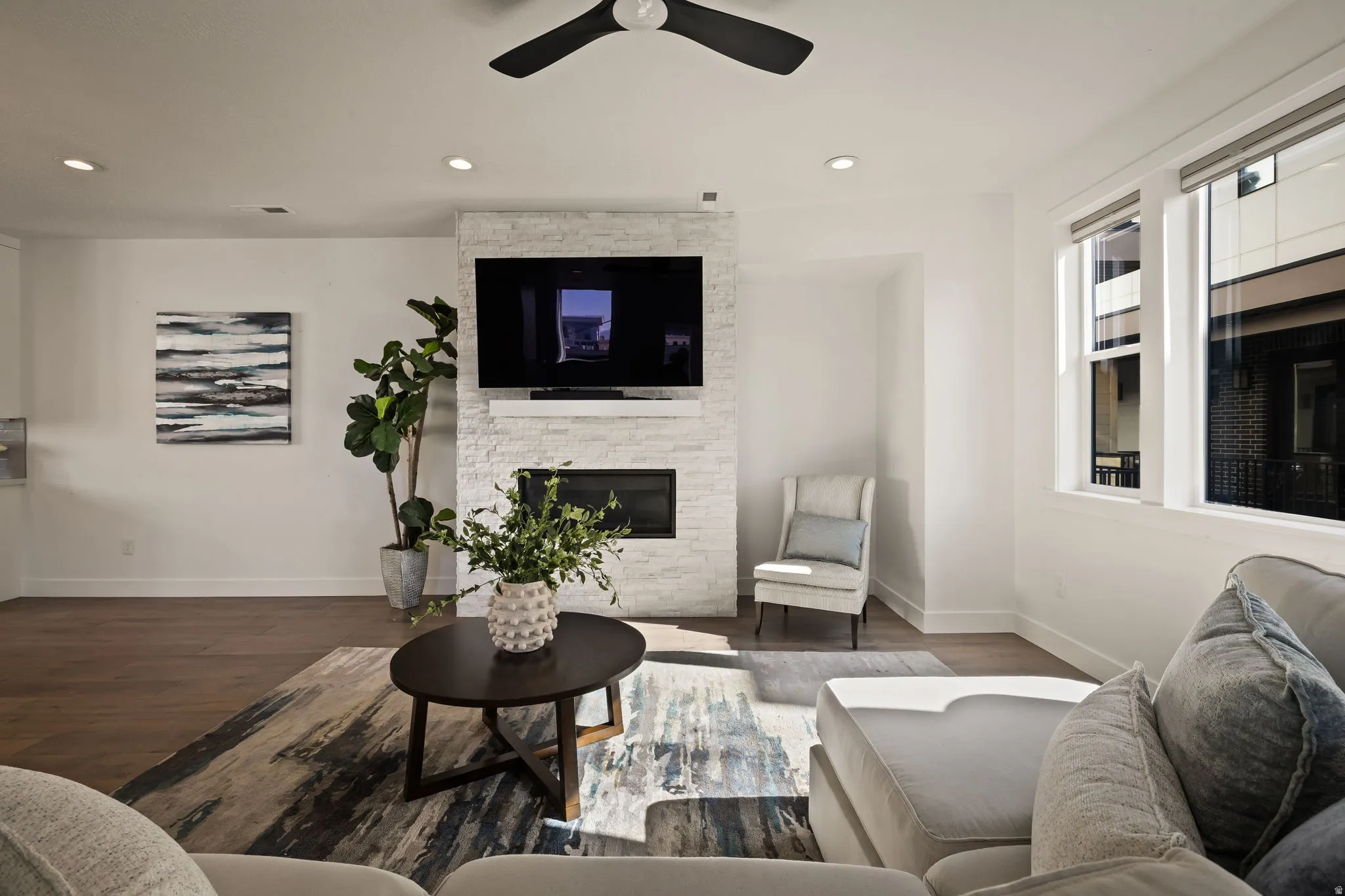 Living area with ceiling fan, a fireplace, wood finished floors, and recessed lighting