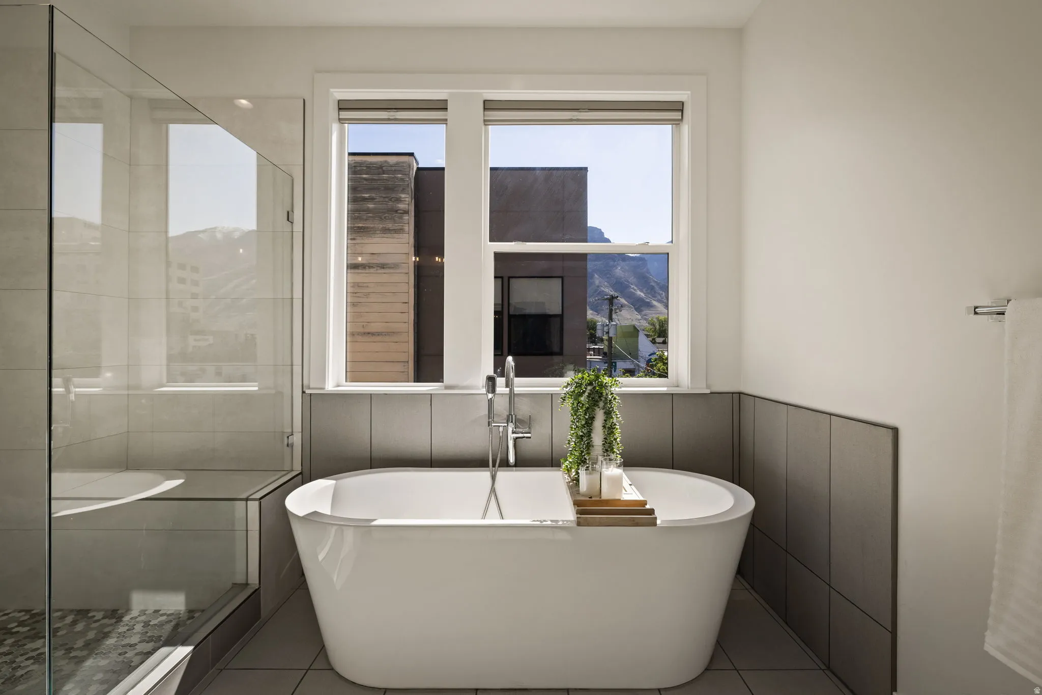 Full bathroom with a stall shower, healthy amount of natural light, a freestanding tub, and light tile patterned floors