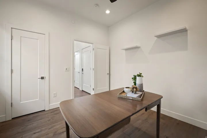 Home office with dark wood-type flooring and recessed lighting