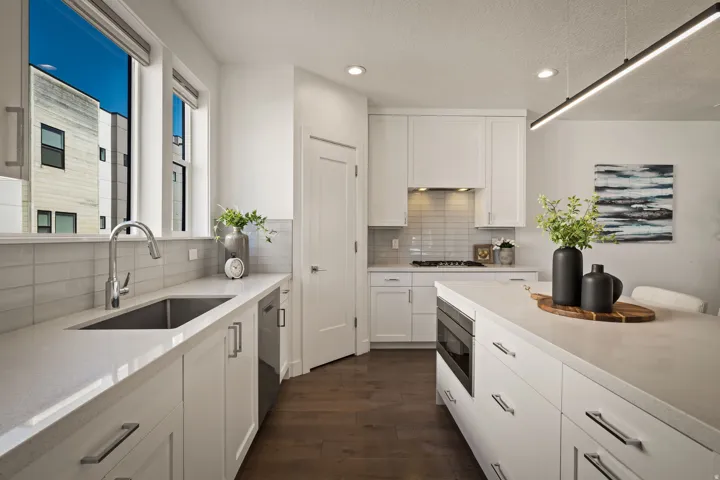 Kitchen with white cabinets, dark wood finished floors, recessed lighting, decorative backsplash, and stainless steel appliances