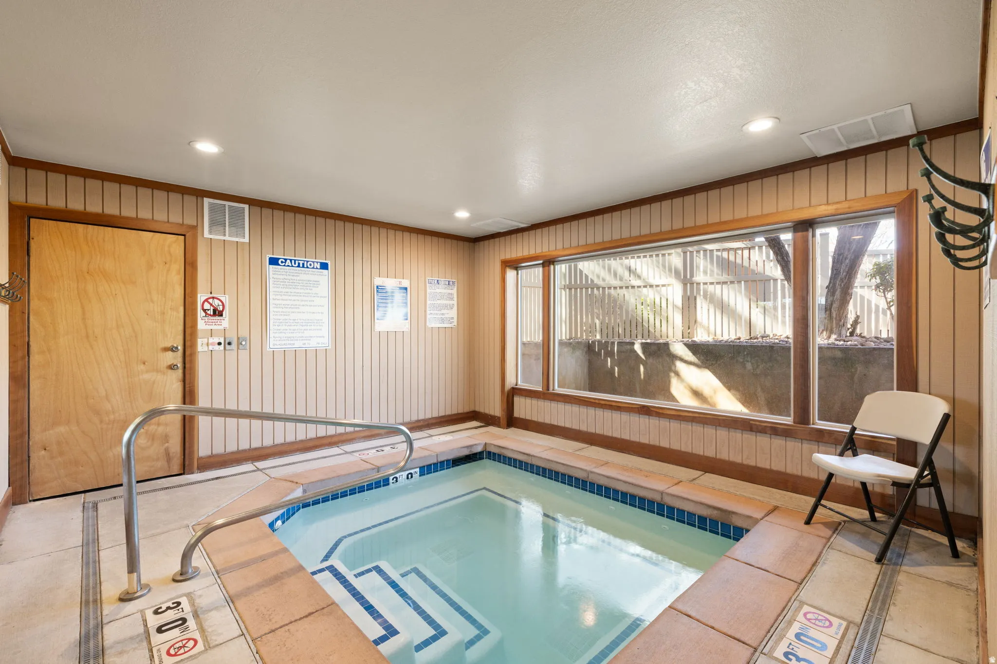 Indoor spa with tiled steps and stainless steel handrail