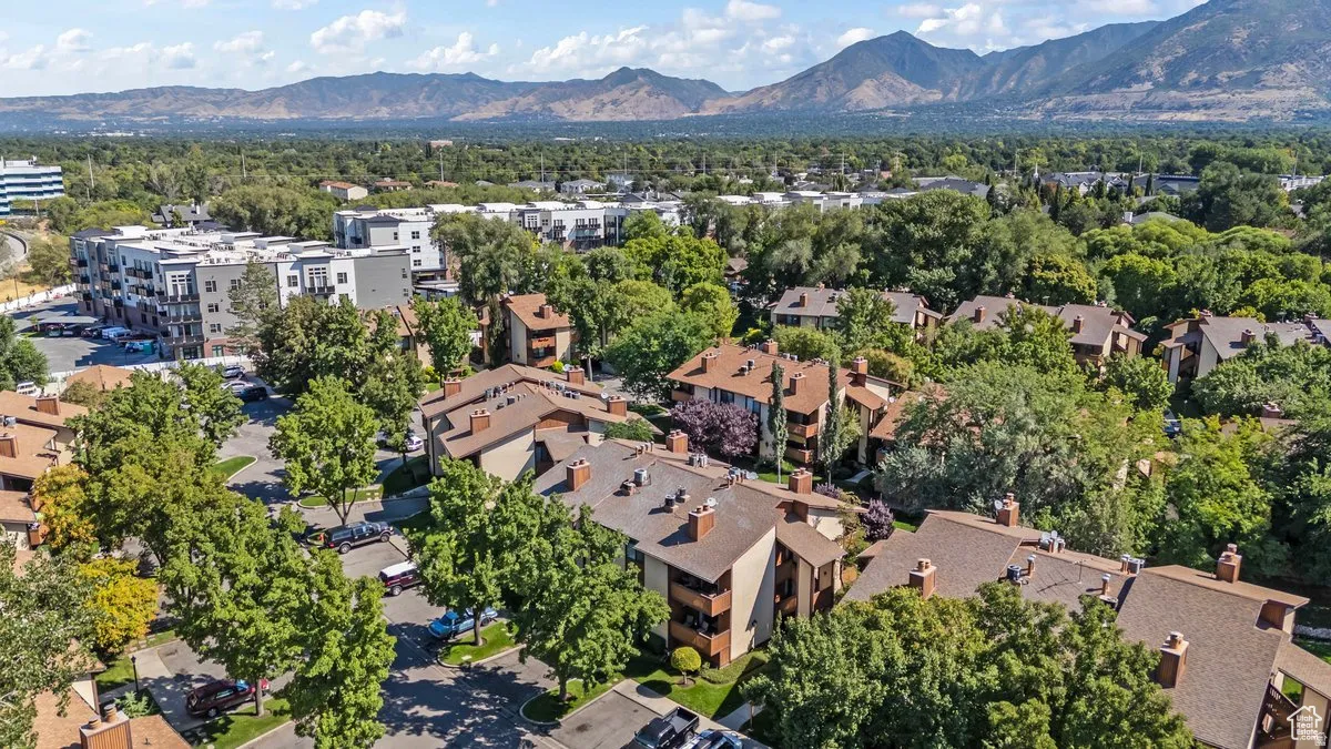 Aerial perspective showcasing a residential community with mature trees and mountain backdrop