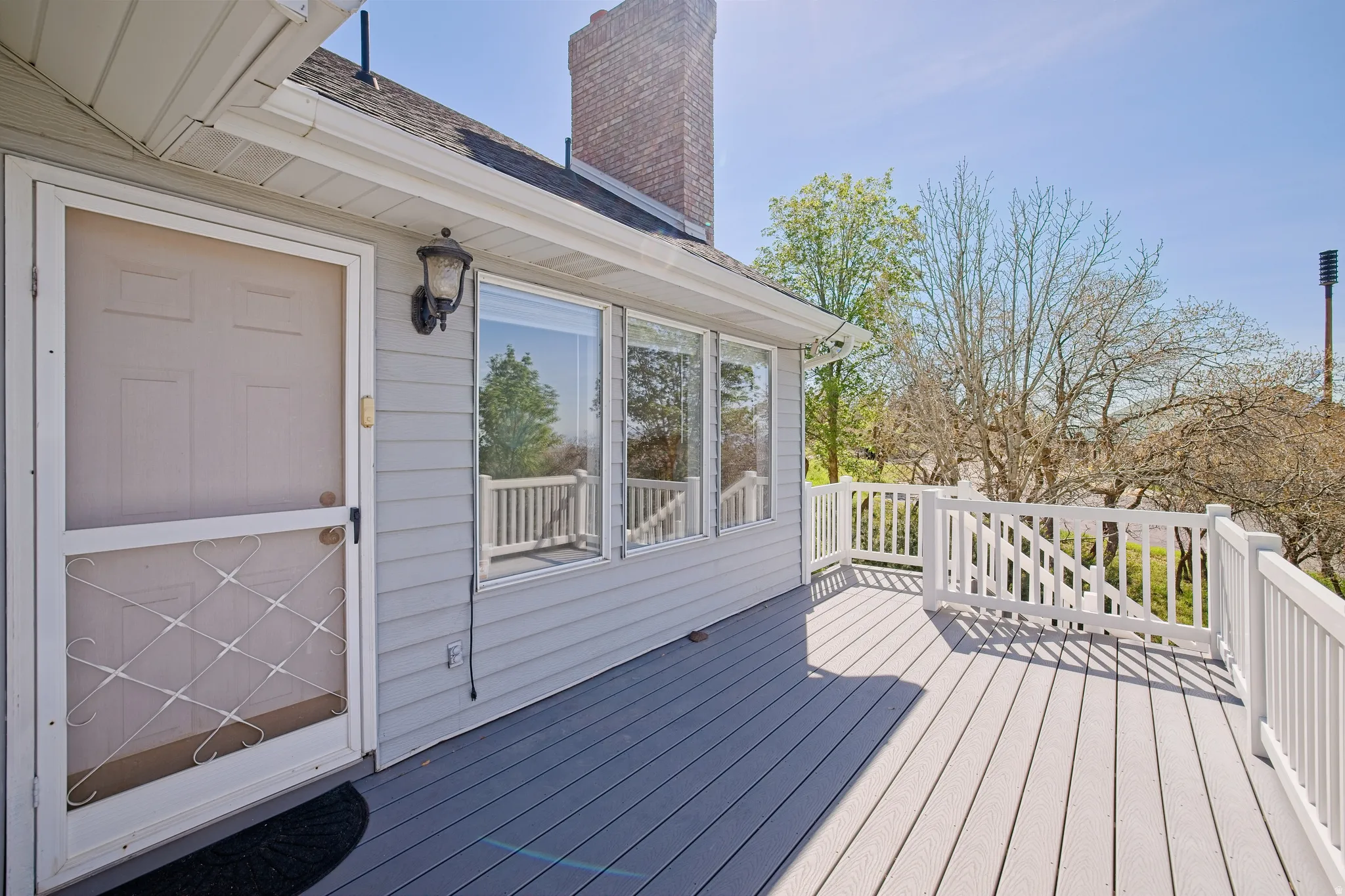 Multiple decks and stairs leading to the patio, basement exterior entrance, and yard.