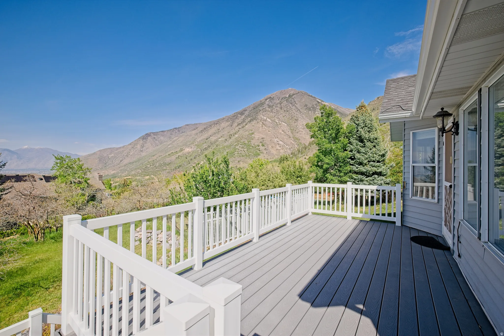 Spacious outdoor deck with composite decking and white railings