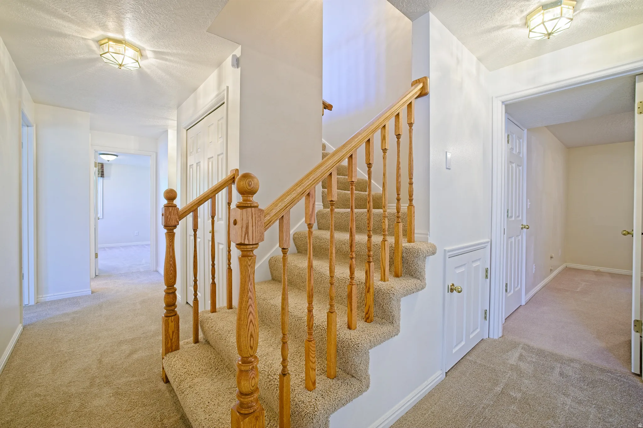 Carpeted staircase with wooden balusters and handrails