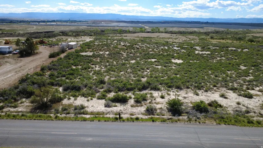 Expansive land parcel featuring natural shrubbery and a distant mountainous backdrop