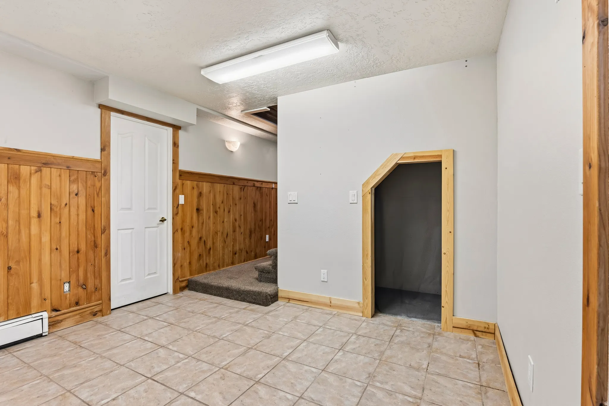 Room featuring tile flooring and wood paneling on lower walls