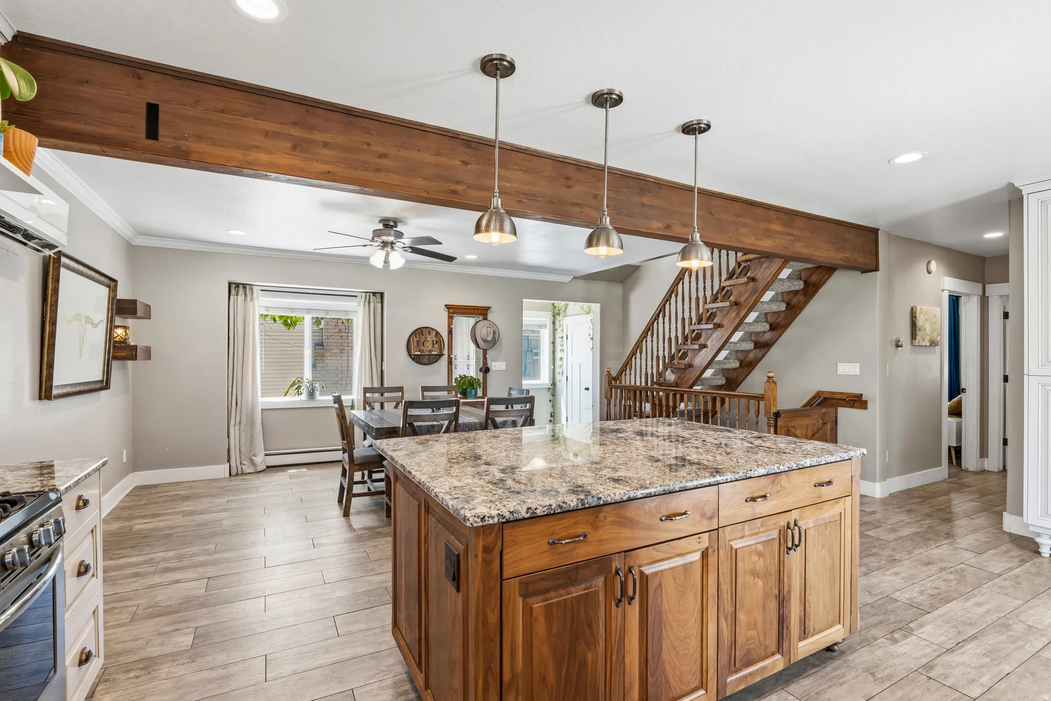 Central kitchen island featuring a granite countertop and rich wood cabinetry with bronze hardware