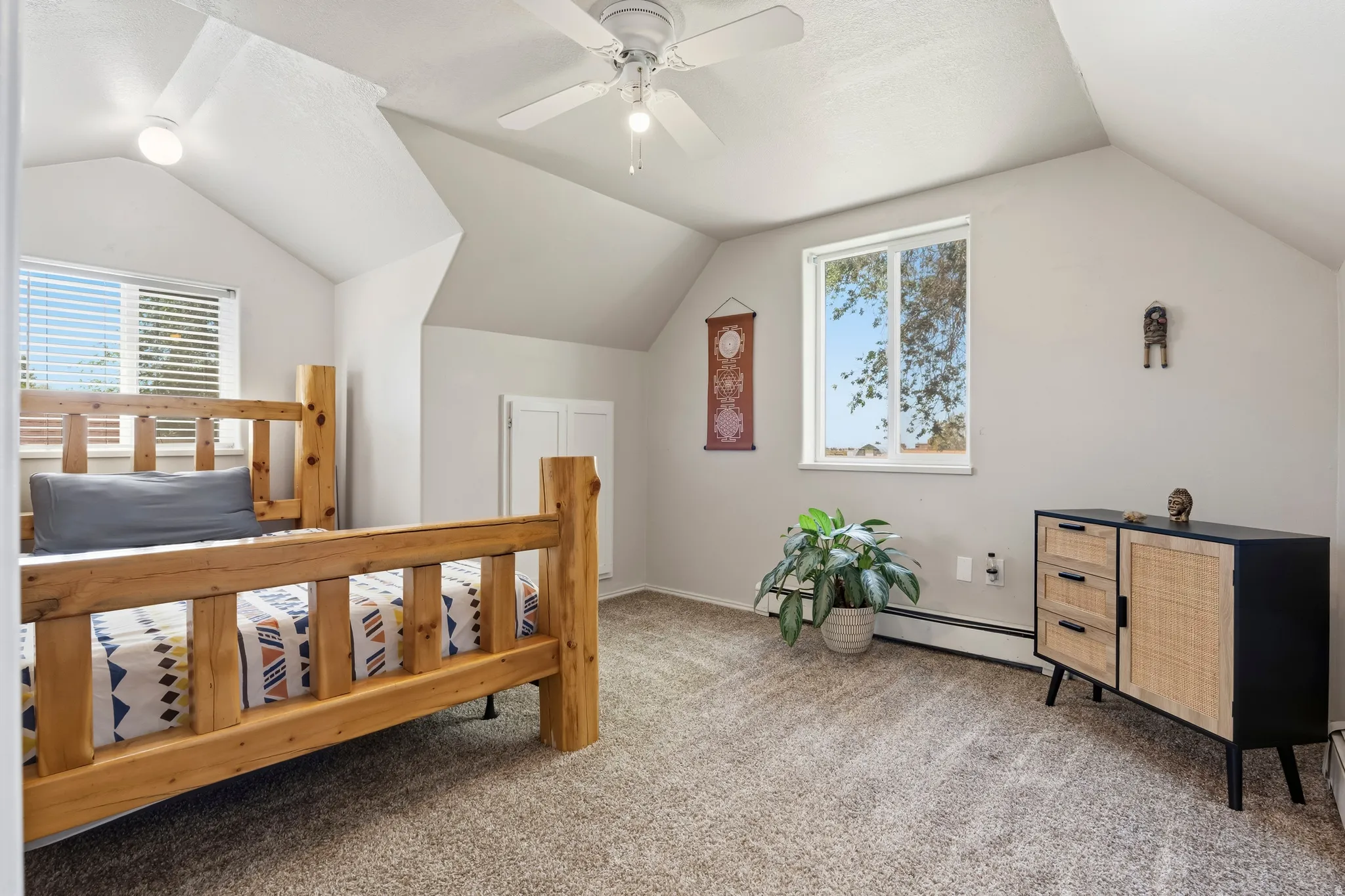 Vaulted ceiling room featuring carpet flooring, a window with horizontal blinds, and a ceiling fan with integrated lighting