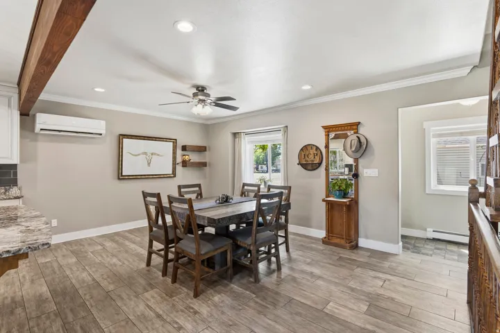 Dining area featuring wood-finish flooring and crown molding