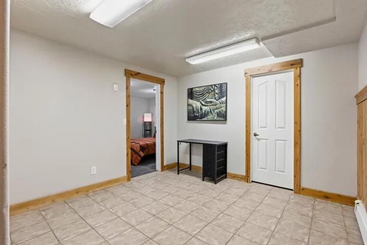 Neutral-toned ceramic tile flooring with contrasting wood trim and doors