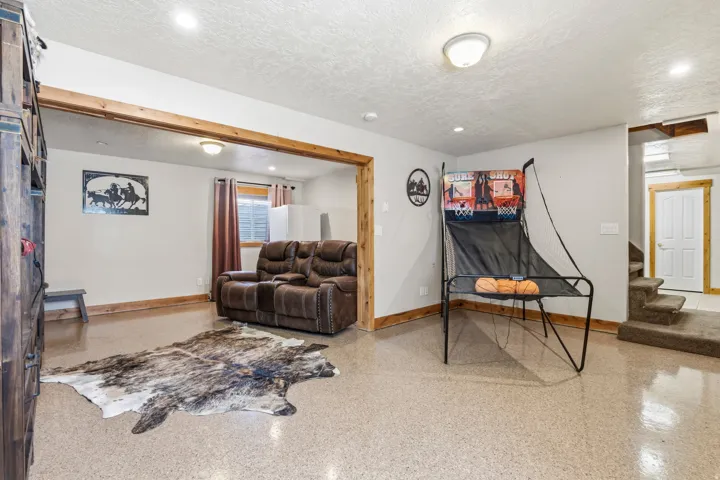 Recessed lighting illuminates an open space with light-colored walls and exposed wood trim