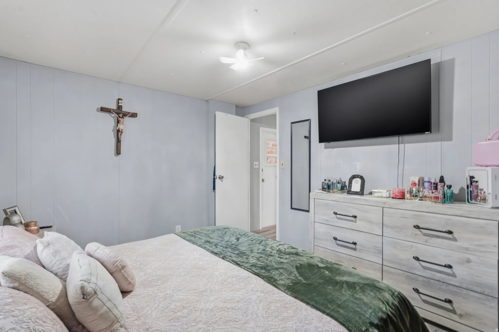 Bedroom featuring light blue paneling and a white ceiling with a flush-mount light fixture