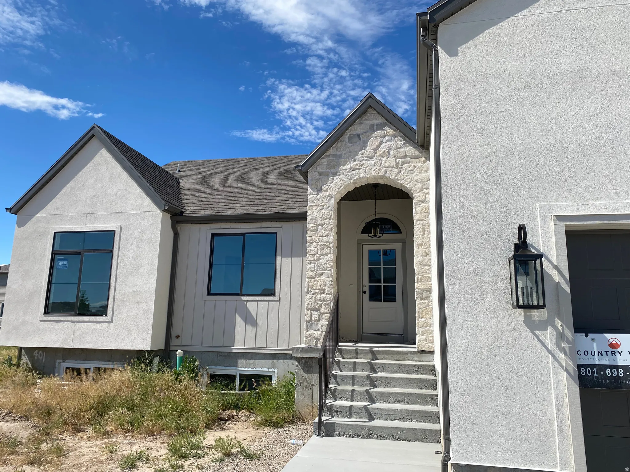 Exterior featuring a stone-clad entry arch and a paneled front door with an arched transom