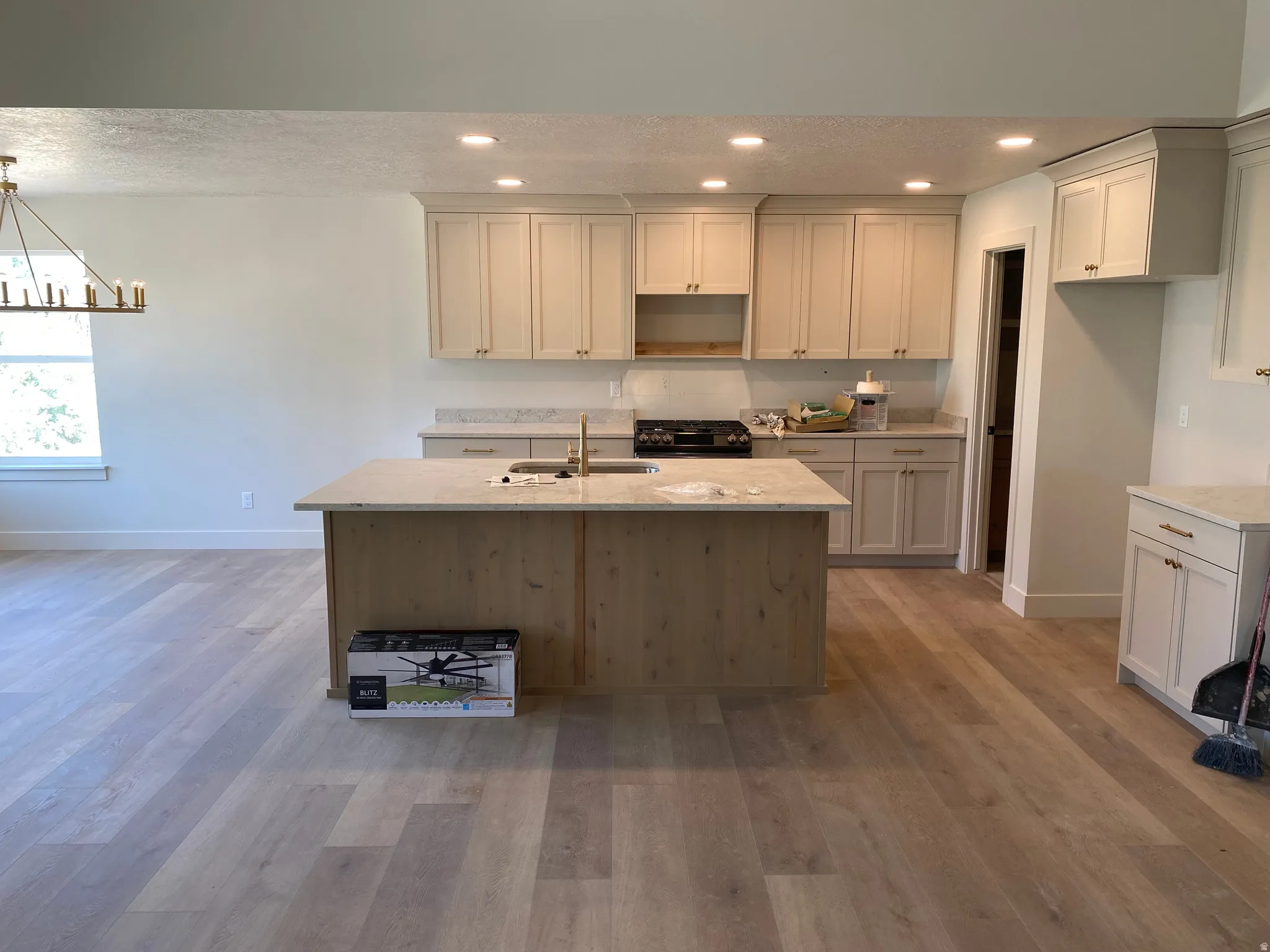 Contemporary kitchen featuring an expansive center island with an integrated sink and gooseneck faucet