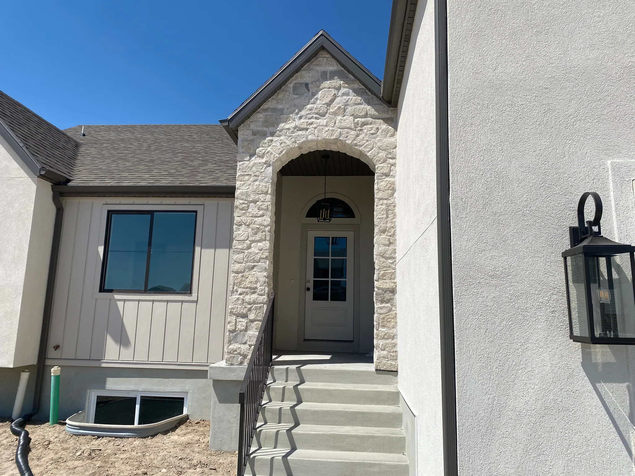 Stone archway entry featuring a white paneled front door with an arched transom window
