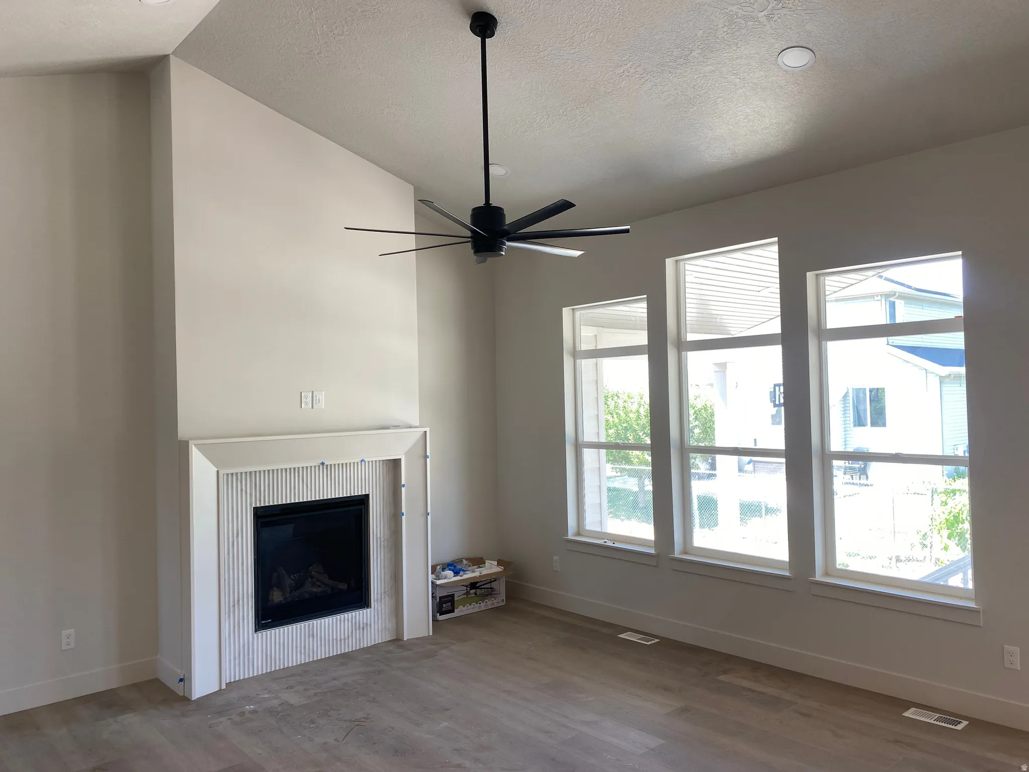 Vaulted ceilings complementing a modern fireplace with fluted tile surround and a clean mantel