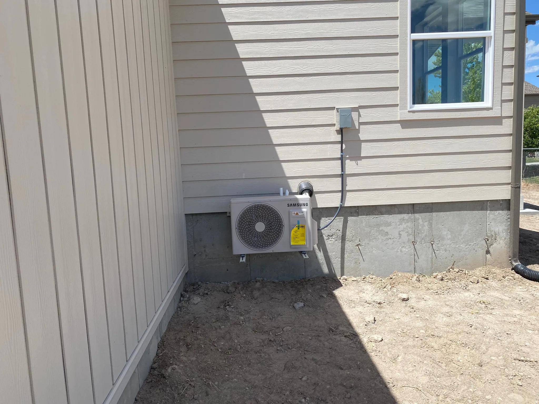 New exterior air conditioning unit installed on a concrete foundation