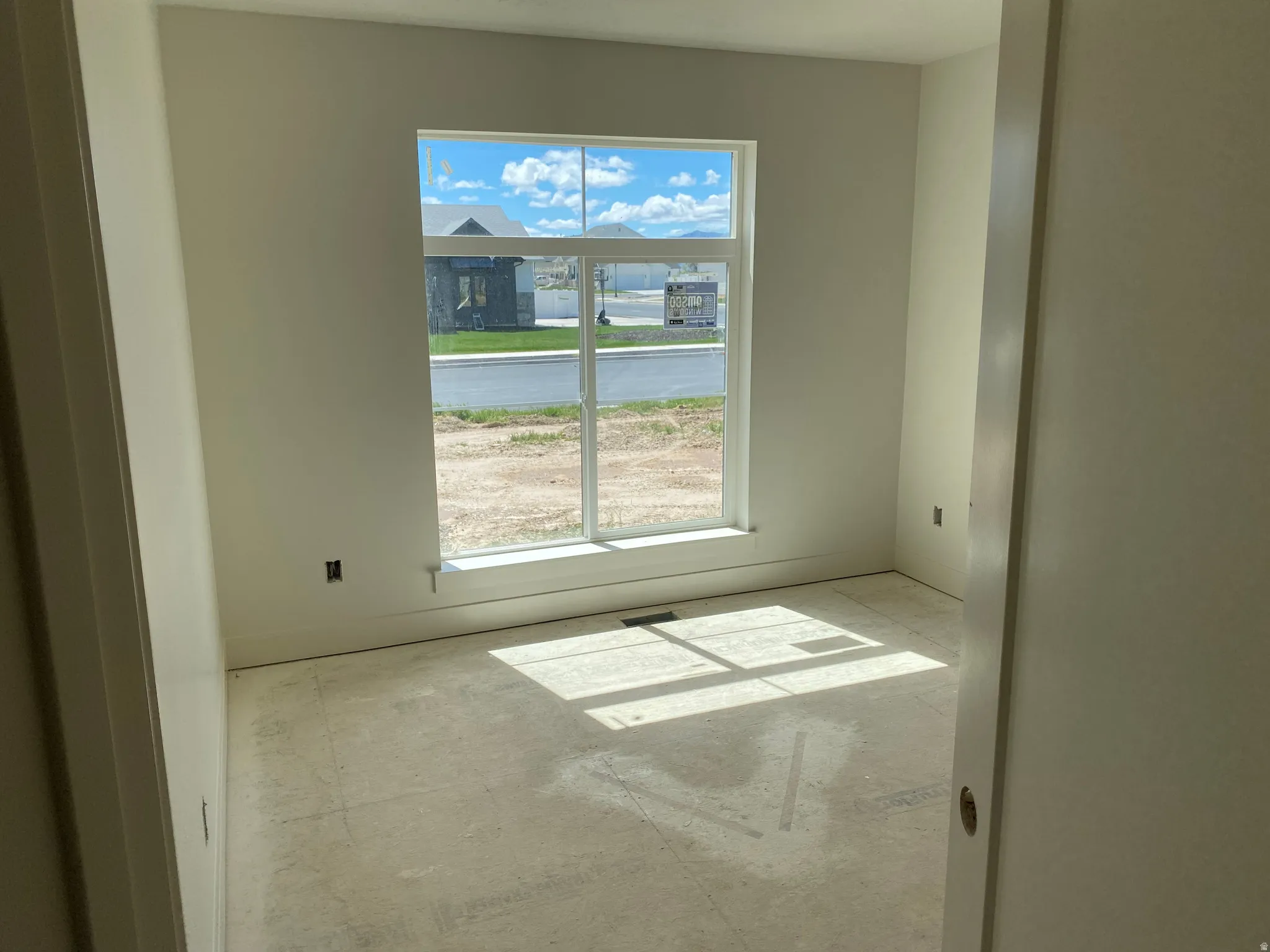 Room featuring a large window with white trim, capturing natural light