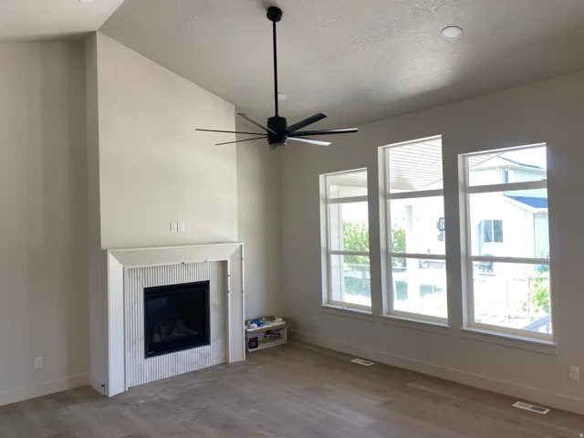 Vaulted ceilings complementing a modern fireplace with fluted tile surround and a clean mantel
