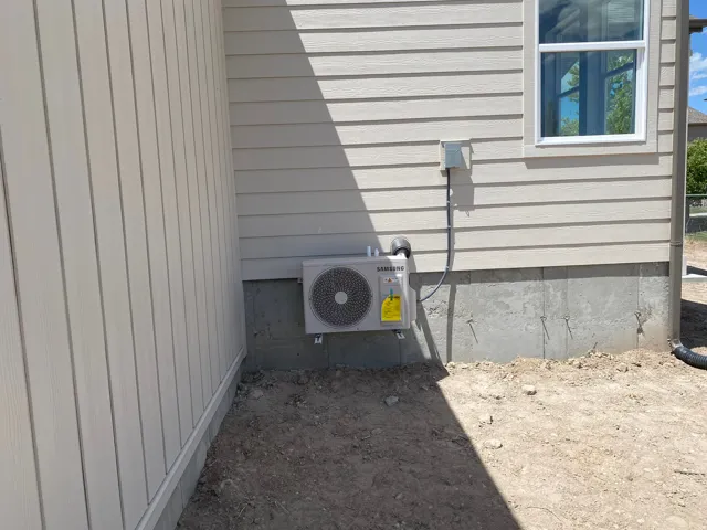 New exterior air conditioning unit installed on a concrete foundation
