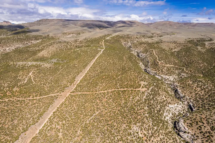 Expansive natural landscape featuring rolling hills, varied topography, and a prominent canyon