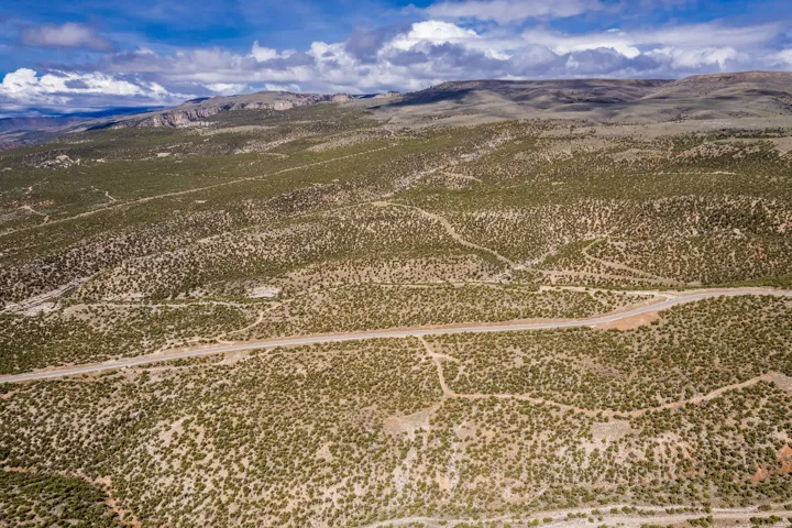Expansive raw land featuring varied topography, natural scrub brush, and visible unpaved roads traversing the landscape