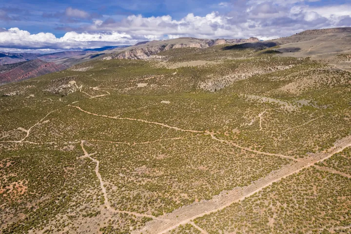 Expansive land parcel featuring natural terrain and established dirt paths
