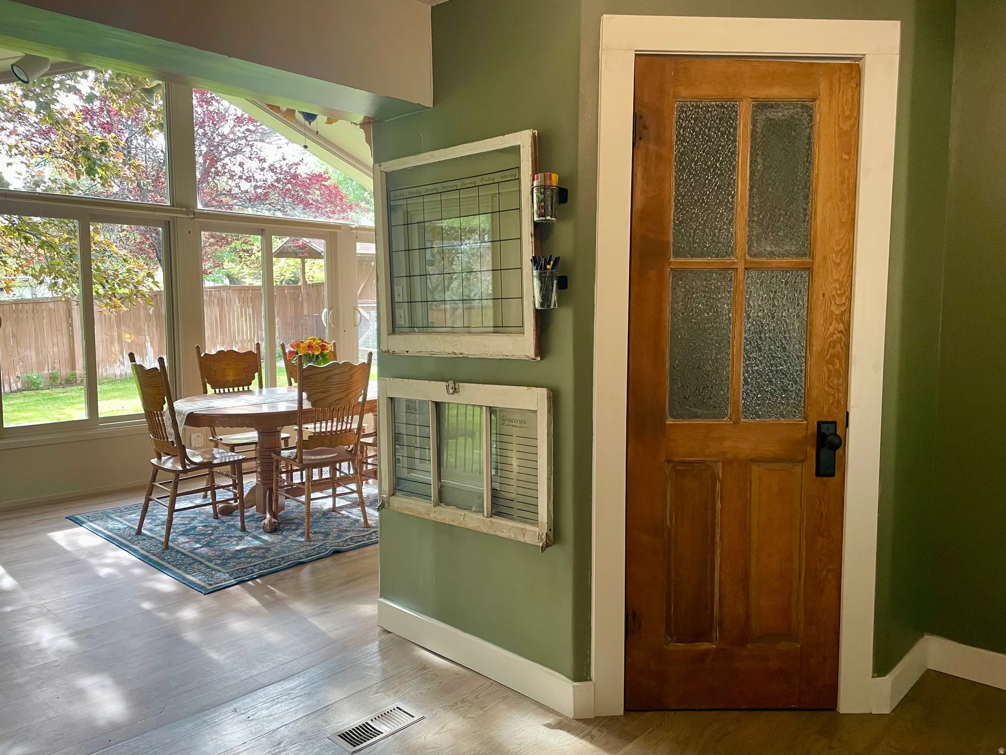 Sunroom featuring expansive windows, wood-finish flooring, and direct yard access