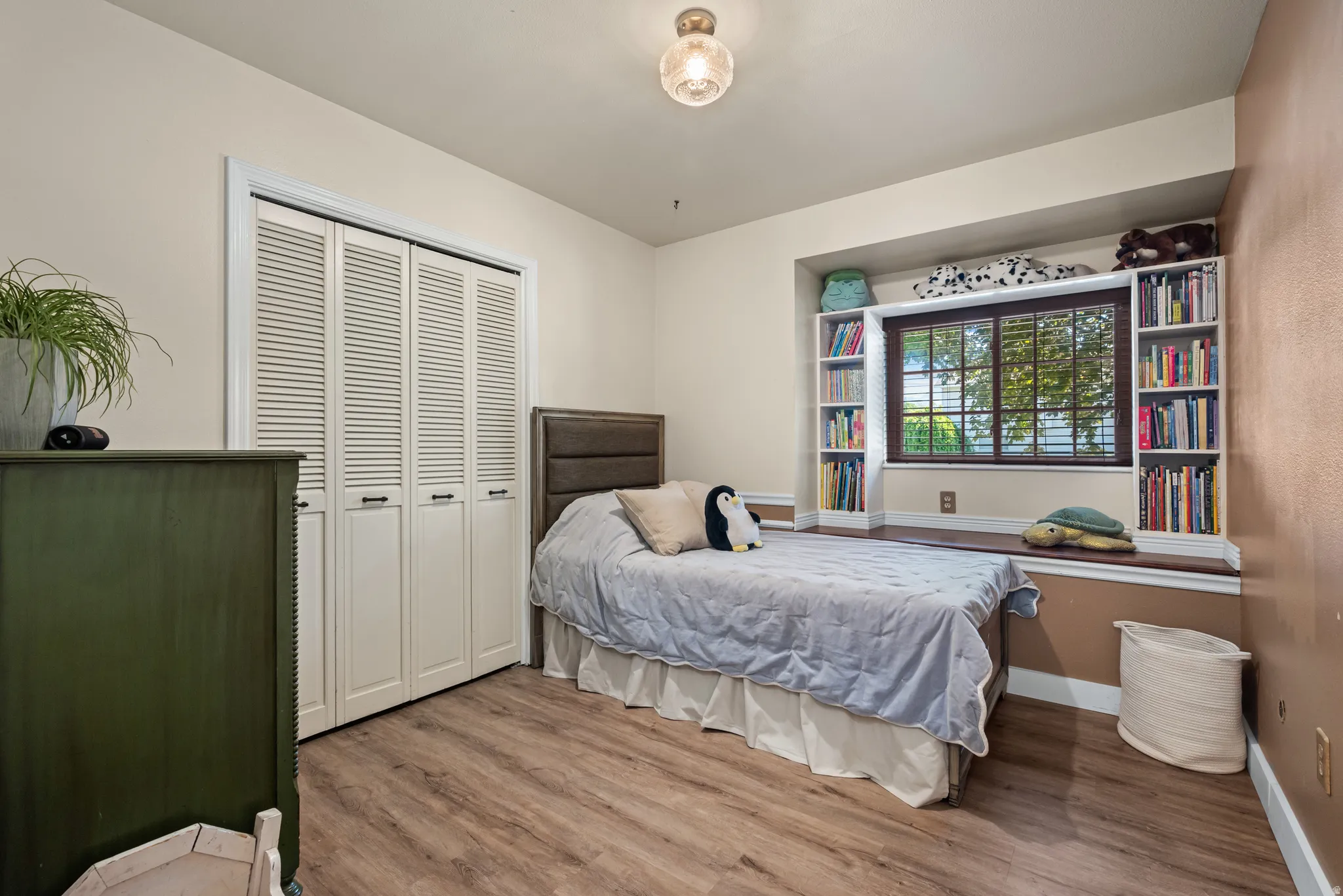 Recessed window feature with built-in shelving, a window seat, and wood-finish blinds