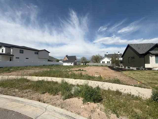 Spacious buildable lot featuring a paved pathway and partial curb