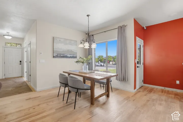Dining area featuring light wood-finish flooring and a contemporary chandelier