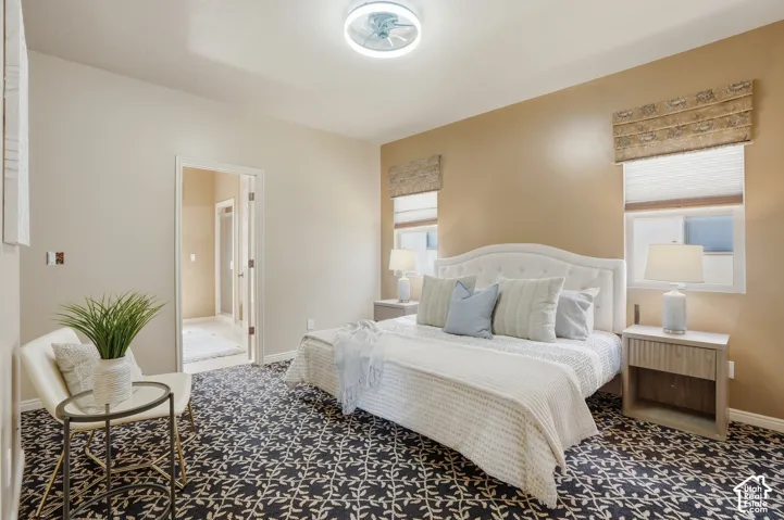 Owners suite, featuring patterned carpeting, neutral wall tones, and a coffered ceiling with a flush-mount light fixture
