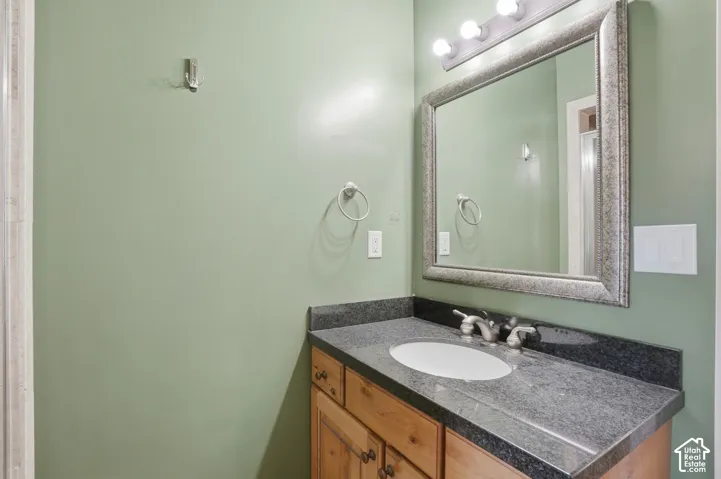 Bathroom vanity featuring a granite countertop, integrated sink, and brushed nickel fixtures