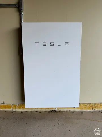 Wall-mounted Tesla energy storage system with visible conduit