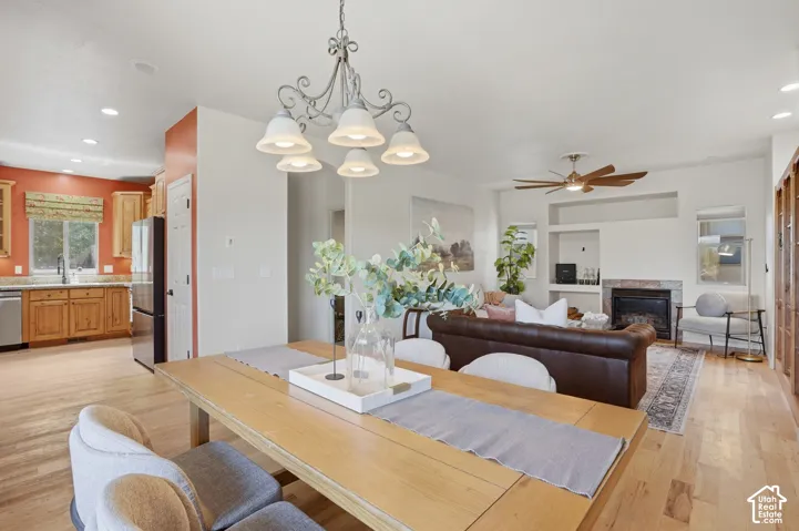 Open-concept living area featuring wood-finish flooring, a decorative chandelier, and recessed lighting