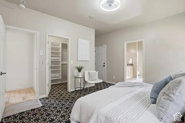 Owners suite, featuring patterned carpet flooring, recessed lighting, and a modern ceiling fan and walk in closet.