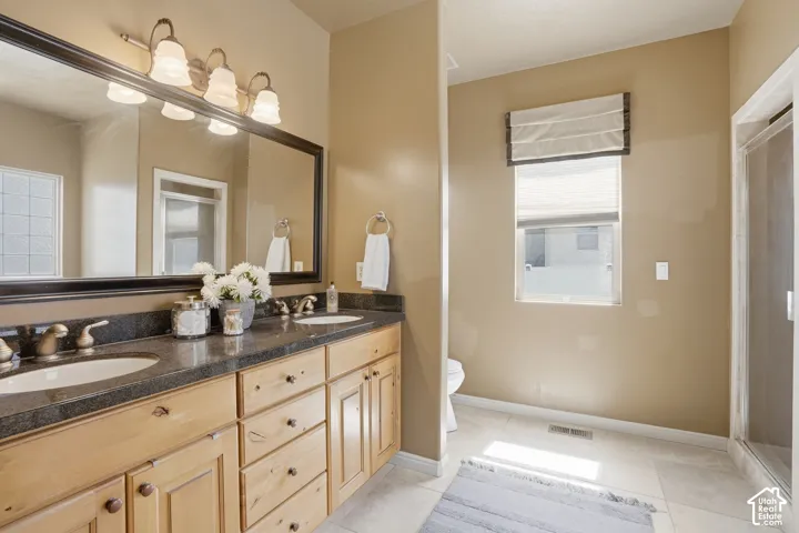 Ensuite bathroom, Double vanity with undermount sinks, bronze finish faucets, and dark countertop