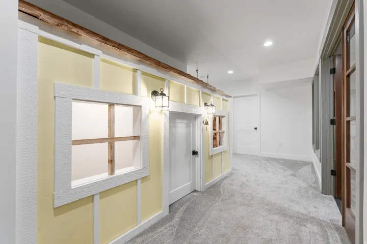 Hallway featuring light yellow walls with white trim, wood-look accents, recessed lighting, and grey carpeting