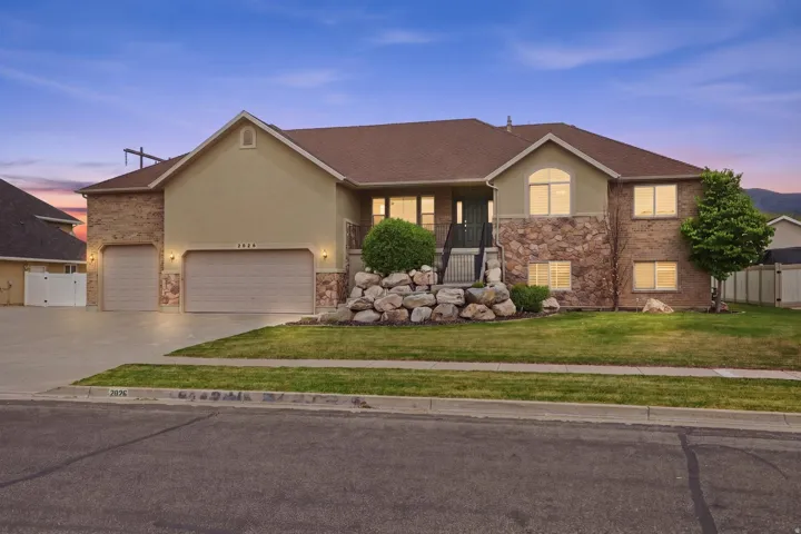 Multi-level residence featuring a stone and stucco exterior, a two-car garage, and an additional single-car garage