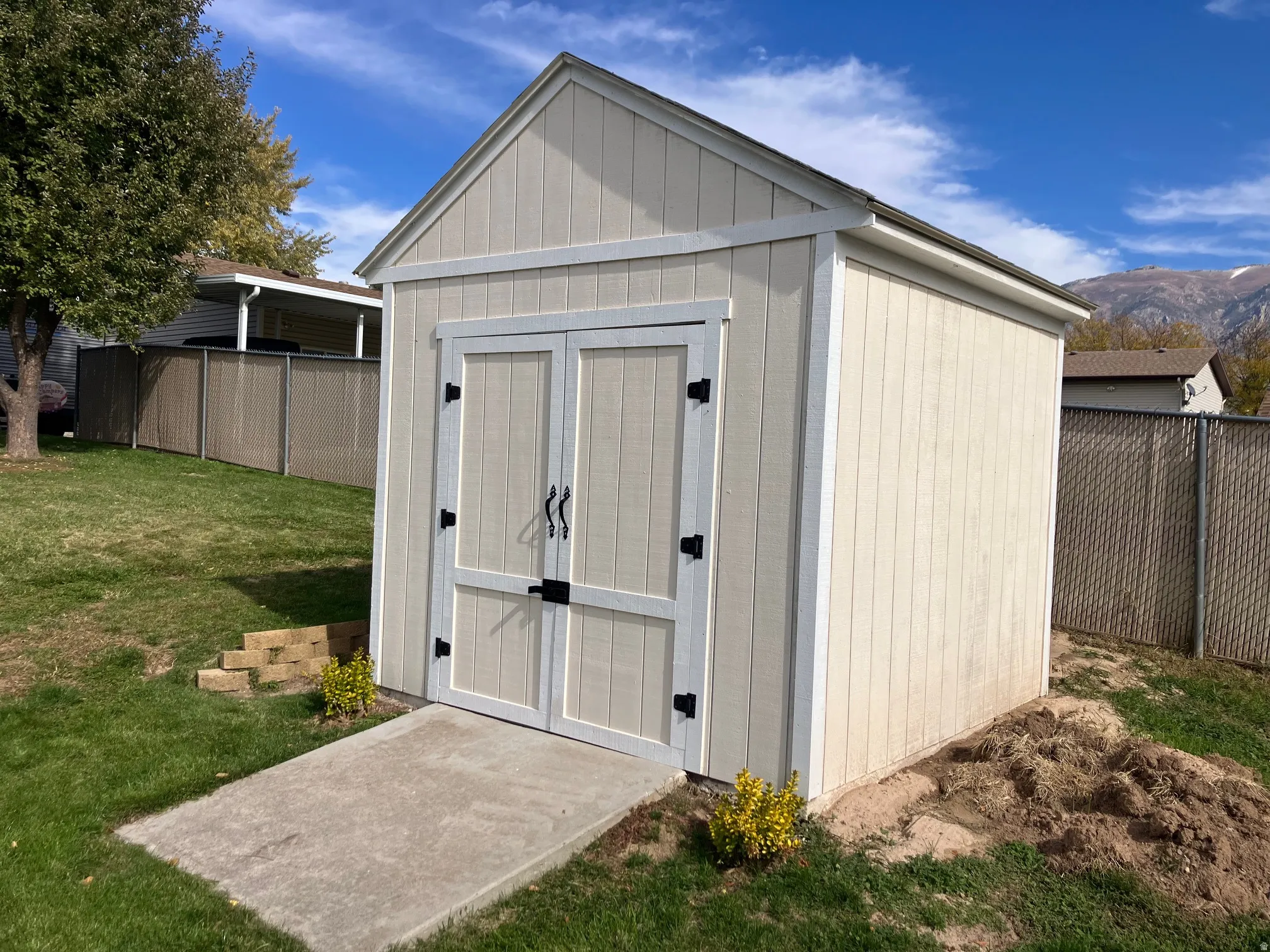 Detached shed featuring panel siding, a gable roof, and double entry doors with black hardware