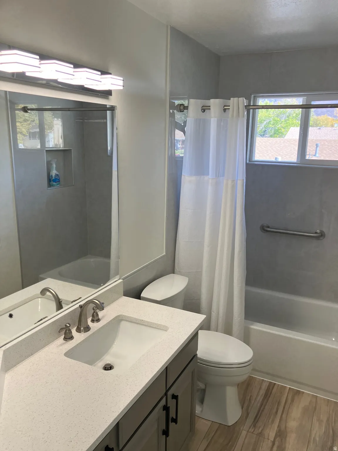 Bathroom featuring a vanity with a white countertop and undermount sink, brushed nickel faucet, and a contemporary light fixture