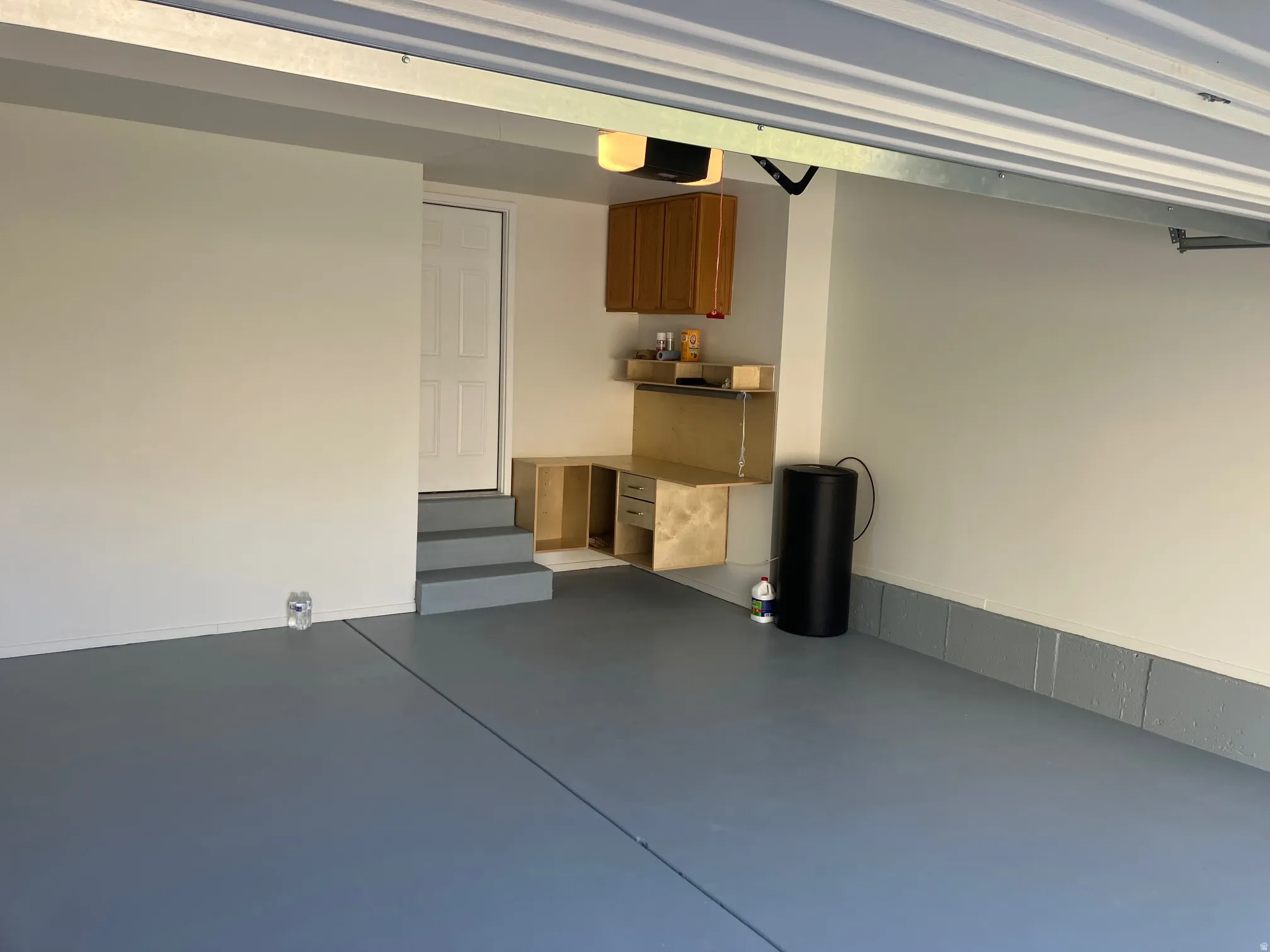 Garage interior with a painted floor, painted walls, and an overhead garage door