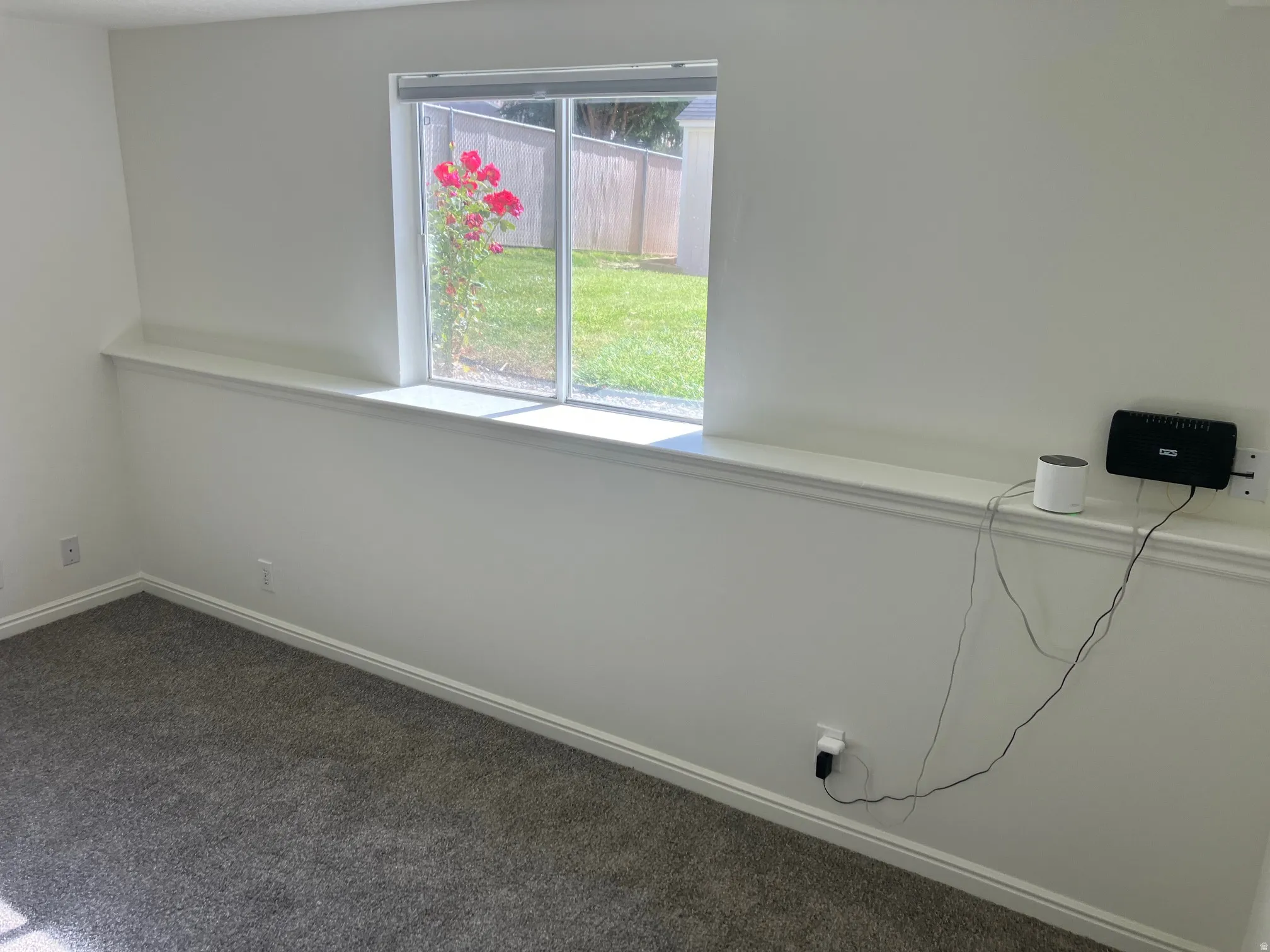 Interior room featuring light-colored walls and grey carpet flooring