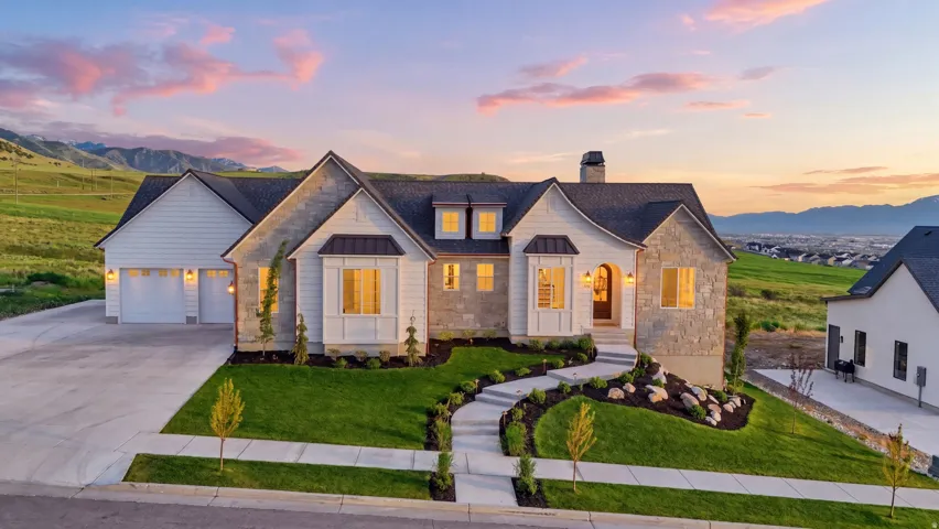 View of front of home with natural stone accents and fully landscaped yard