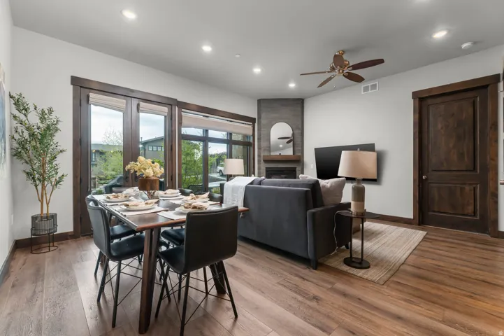 Open-concept living space featuring wood-finish flooring, recessed lighting, and a dark wood trim package