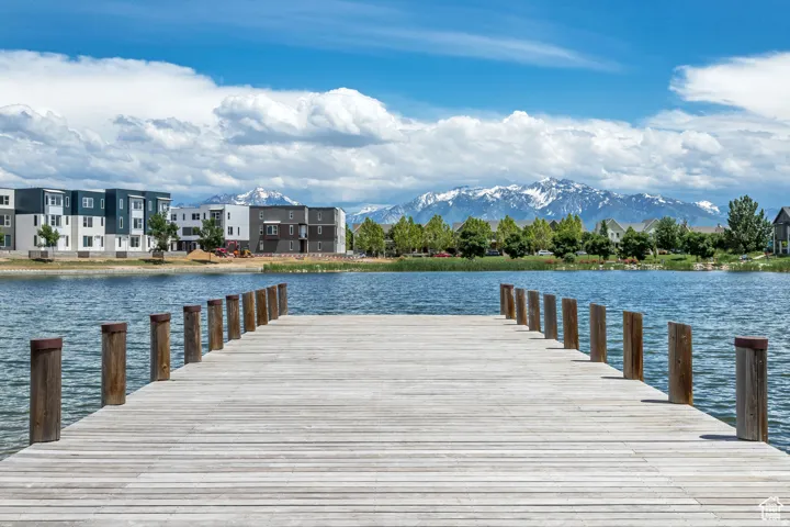 Wooden dock extending over a body of water, with snow-capped mountains in the background