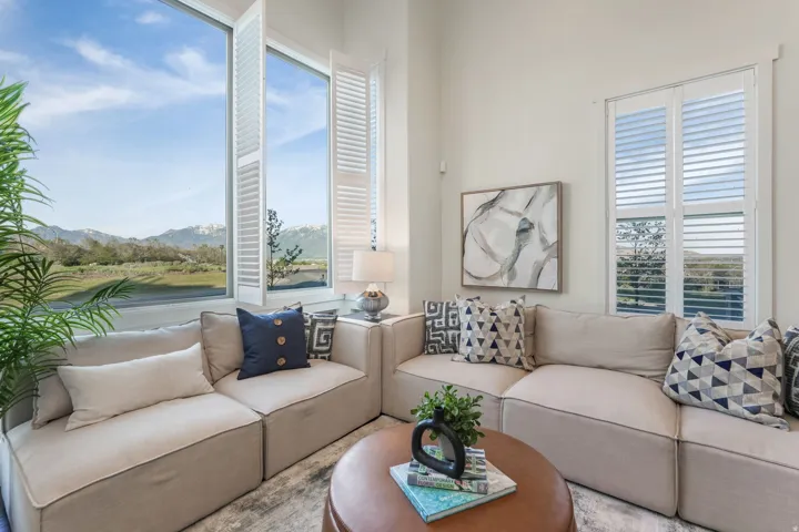 Interior space featuring an expansive window with white plantation shutters, providing abundant natural light and exterior scenery