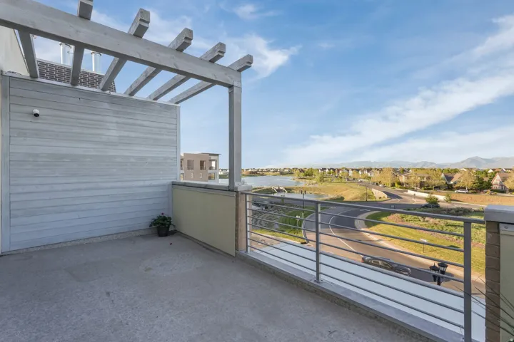 Rooftop patio with a concrete surface, wooden pergola, and horizontal metal railings