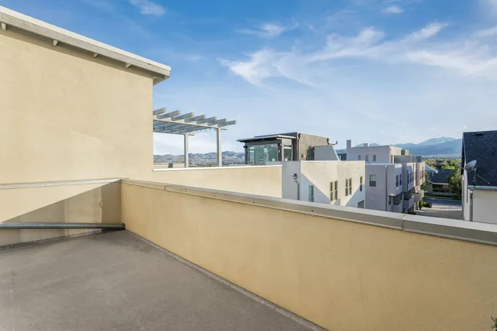 Rooftop patio with light-toned stucco walls and concrete flooring